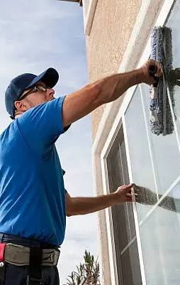 man cleaning window of a home.
